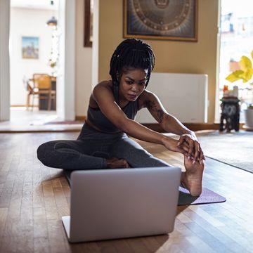 close up of a young woman learning yoga online from her laptop